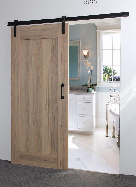 Sahara Melamine Barn Door with natural wood finish and black sliding hardware