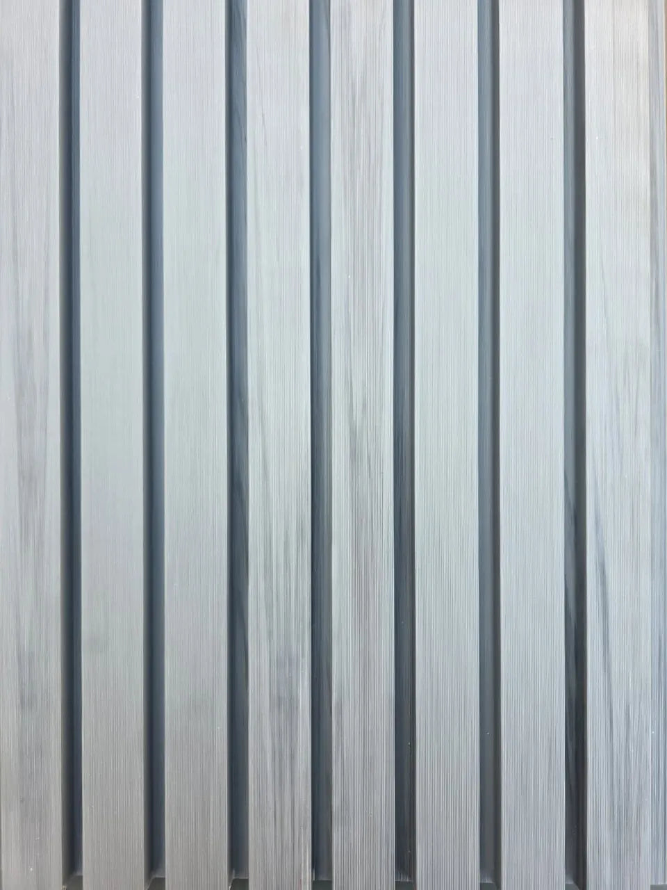 Close-up of 4 Everdeck® Grey Ultra Fluted PVC wall panels showing deep vertical grooves and timber-look texture.