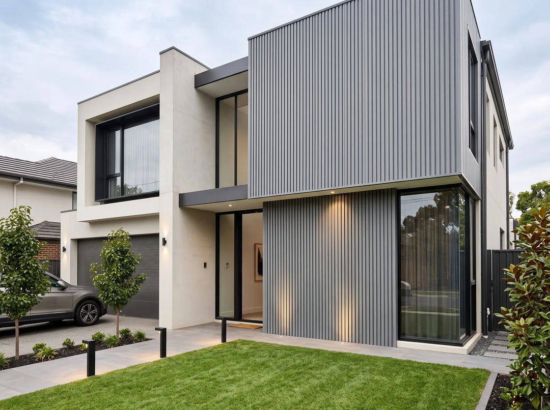 Grey fluted wall cladding installed vertically on the façade of a modern two-storey home.