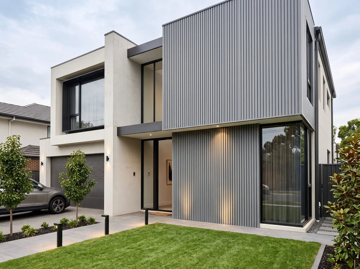Grey fluted wall cladding installed vertically on the façade of a modern two-storey home.